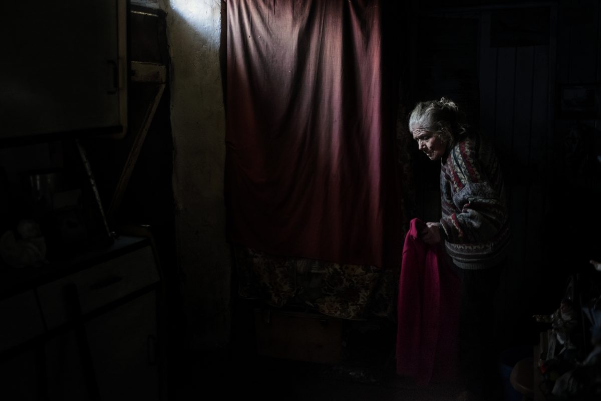 Dans la maison de Marie-Claude, à Kerberou. Marie-Claude porte trois pullovers. Le pullover du dessus, je l’ai vu s’effiler, mois après mois, jusqu’à ce que je lui en offre un nouveau. Un pullover lui dure cinq mois minimum. / Extrait de « Marie-Claude, la dame aux poupées », © Mélanie Wenger