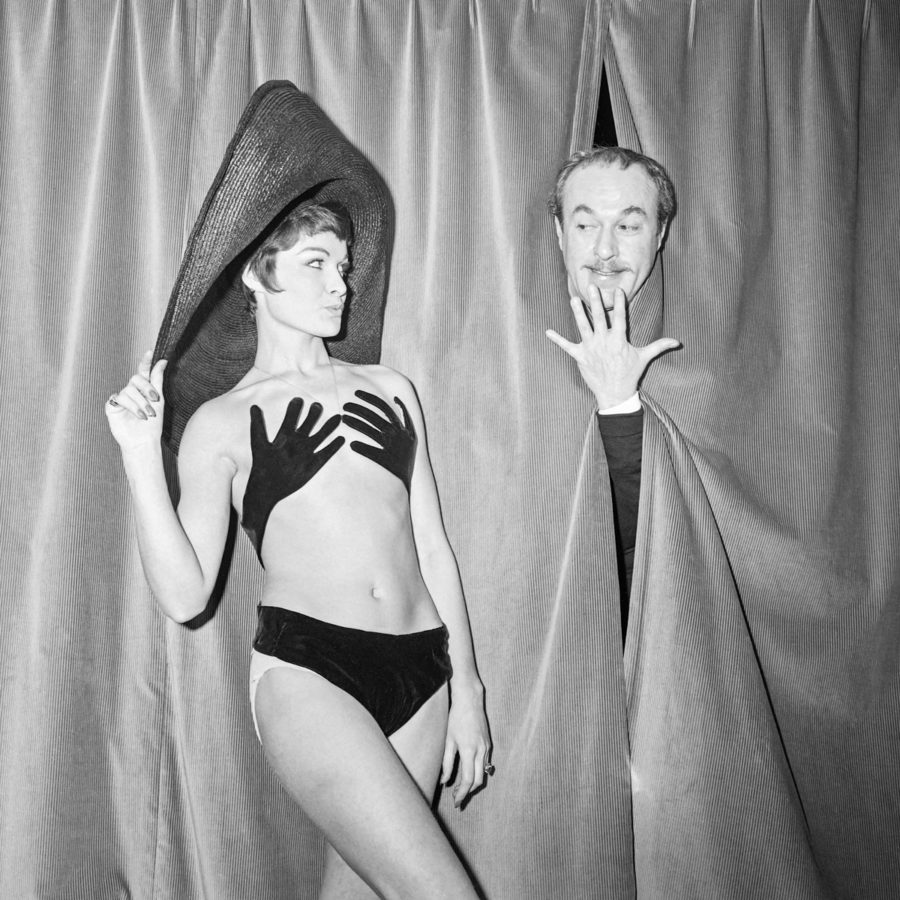 8TG2GU Le couturier français Jacques Esterel jouant sur scène lors de la présentation de son maillot de bain « Hand up » porté par son mannequin vedette Bibelot, le 13 janvier 1965 à Paris.