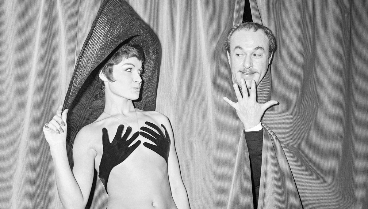 8TG2GU Le couturier français Jacques Esterel jouant sur scène lors de la présentation de son maillot de bain « Hand up » porté par son mannequin vedette Bibelot, le 13 janvier 1965 à Paris.