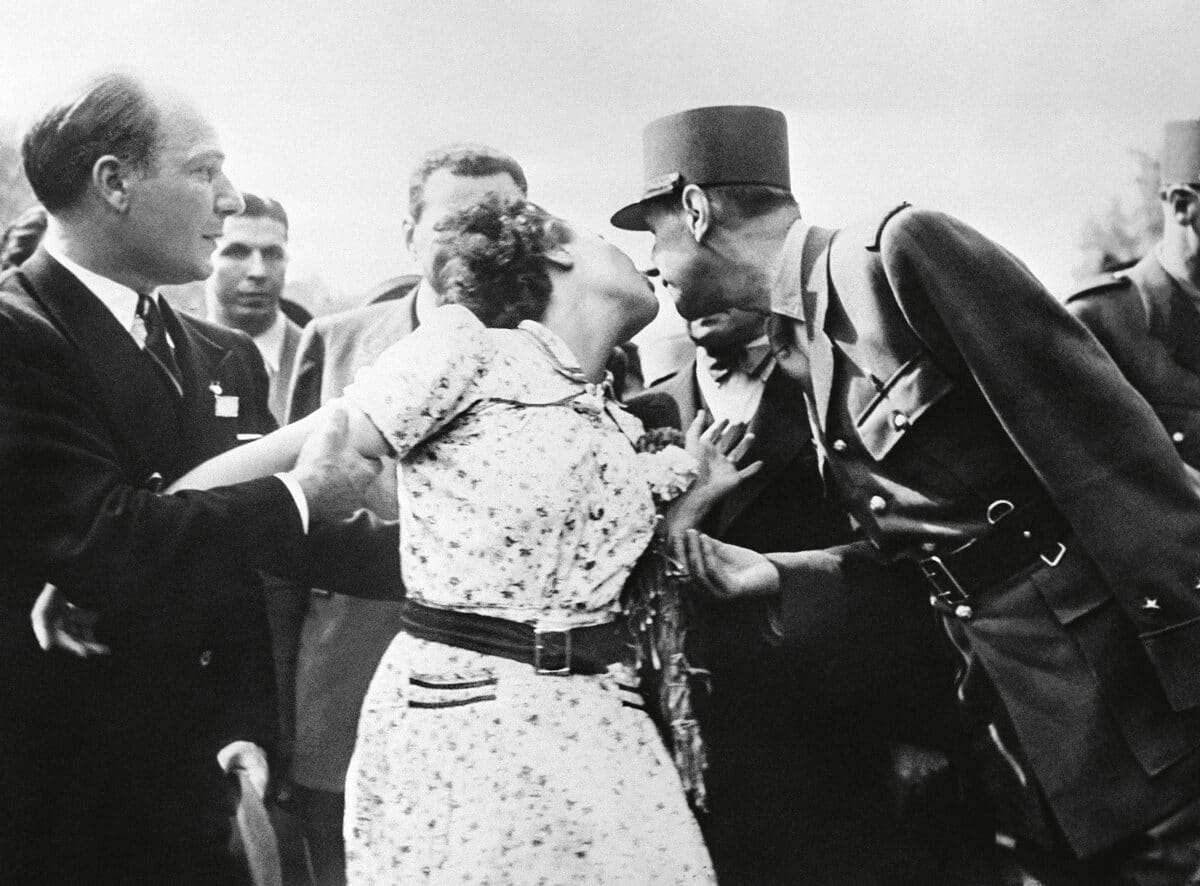 Paris, 24 août 1944. Une Parisienne embrasse le général de Gaulle lors d’un défilé sur les Champs-Élysées après la libération de Paris.