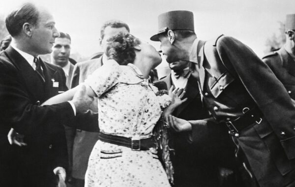 Paris, 24 août 1944. Une Parisienne embrasse le général de Gaulle lors d’un défilé sur les Champs-Élysées après la libération de Paris.
